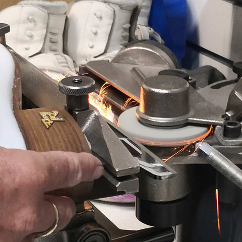 Close up of an ice skate getting its blades sharpened.